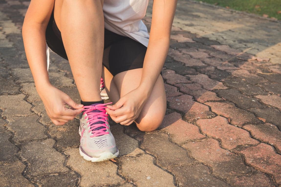 Person tying running shoes for exercise